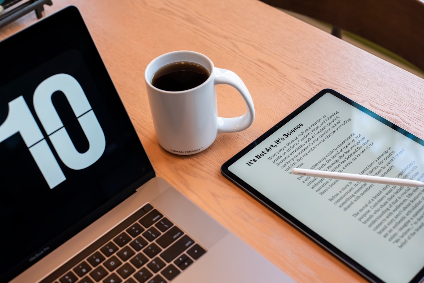 Pantalla de portátil con el número 10 junto a una taza de café sobre un escritorio.
